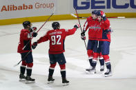 Washington Capitals right wing Tom Wilson, right, celebrates his game-winning goal with teammates Dmitry Orlov, from left, Evgeny Kuznetsov and Aliaksei Protas in an overtime period of an NHL hockey game against the Winnipeg Jets, Tuesday, Jan. 18, 2022, in Washington. Washington won 4-3 in overtime. (AP Photo/Patrick Semansky)