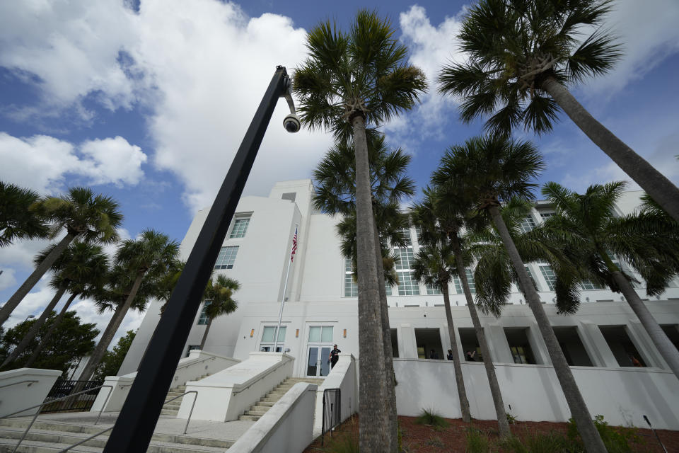 FILE - A police officer stands beside an entrance to the Alto Lee Adams Sr. U.S. Courthouse, Aug. 15, 2023, in Fort Pierce, Fla. The federal judge overseeing the classified documents prosecution of Trump is expected to set a trial date during a court hearing on March 1, 2024. (AP Photo/Rebecca Blackwell, File)