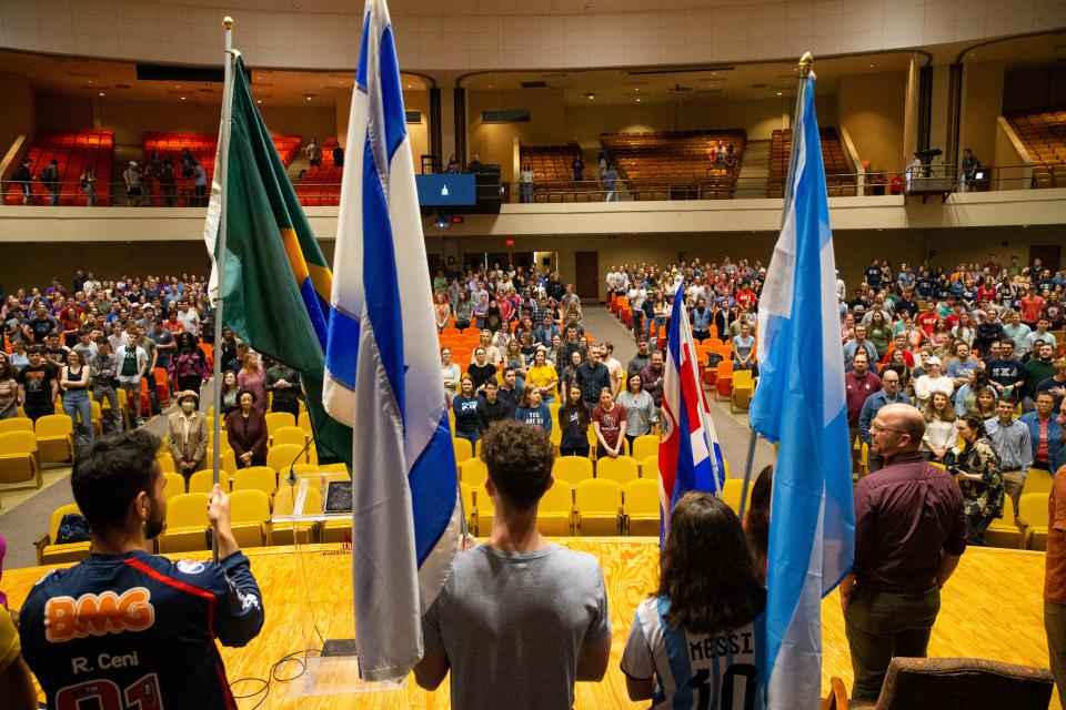 International students stand in front of the student body holding the flags of their home country during International Student Day in Loyd Auditorium at Freed-Hardeman University in Henderson, Tenn., on Thursday, February 23, 2023. Students representing 19 countries carried their home country flags into the auditorium and then introduced their countries. 