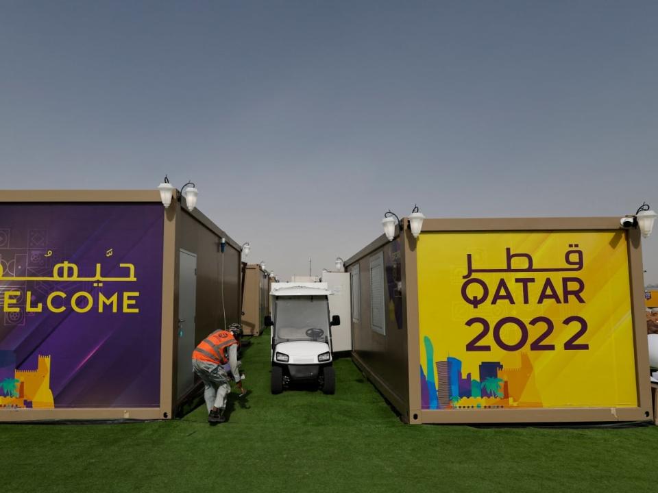 A worker applies finishing touches at a Qatar fan village ahead of the World Cup, which begins on Sunday. (Hamad I Mohammed/Reuters - image credit)