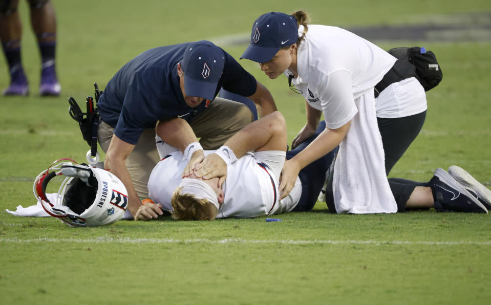 Duquesne quarterback Joe Mischler (11) is looked after by team staff after taking a hit from TCU during the first half of an NCAA college football game Saturday, Sept. 4, 2021, in Fort Worth, Texas. (AP Photo/Ron Jenkins)