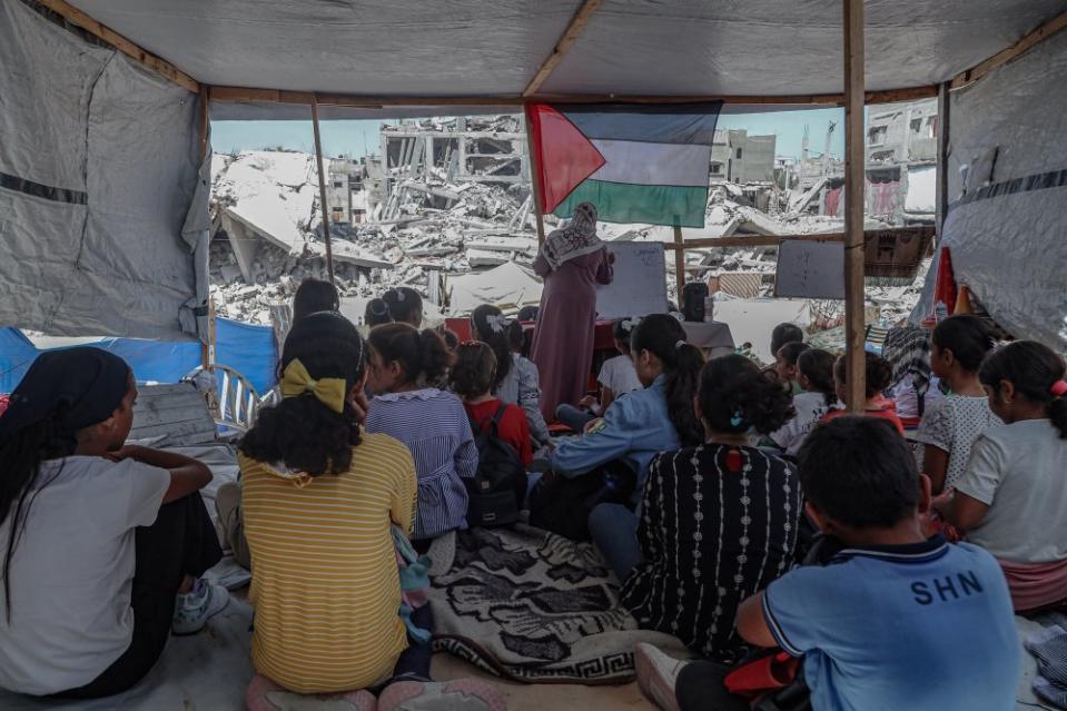 Palestinian teacher Israa Abu Mustafa took the initiative to set up a classroom in a tent on the ruins of her destroyed home with the aim of teaching children as the new school year begins, Sept. 12, 2024.