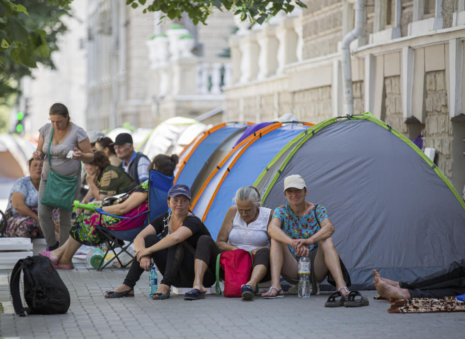 Supporters of the former government camp outside the interior ministry in Chisinau, Moldova, Wednesday, June 12, 2019. Moldova's police chief on Wednesday dismissed six officers who publicly backed a rival government, reflecting a continuing power struggle that has heightened political tensions in the impoverished ex-Soviet nation.(AP Photo/Roveliu Buga)