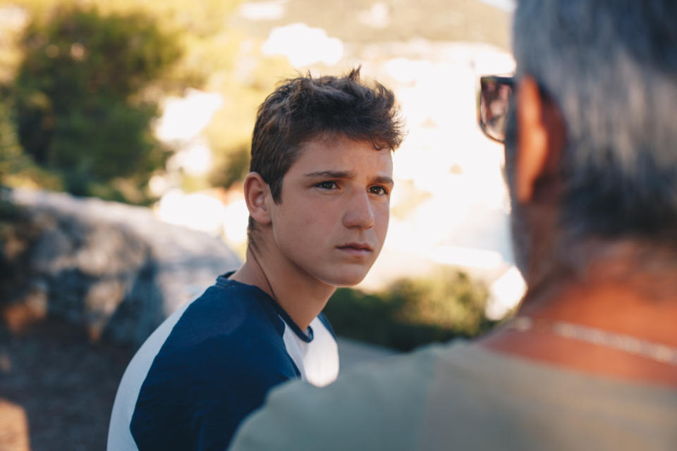 an older man and a young teen talking