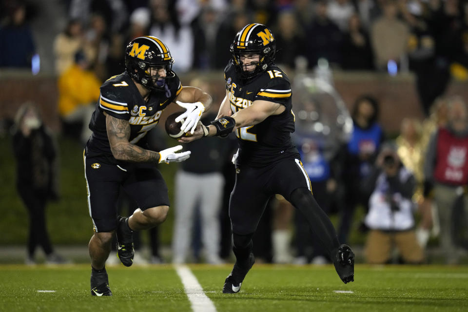 Missouri quarterback Brady Cook, right, hands off to running back Cody Schrader during the first half of an NCAA college football game against Florida Saturday, Nov. 18, 2023, in Columbia, Mo. (AP Photo/Jeff Roberson)