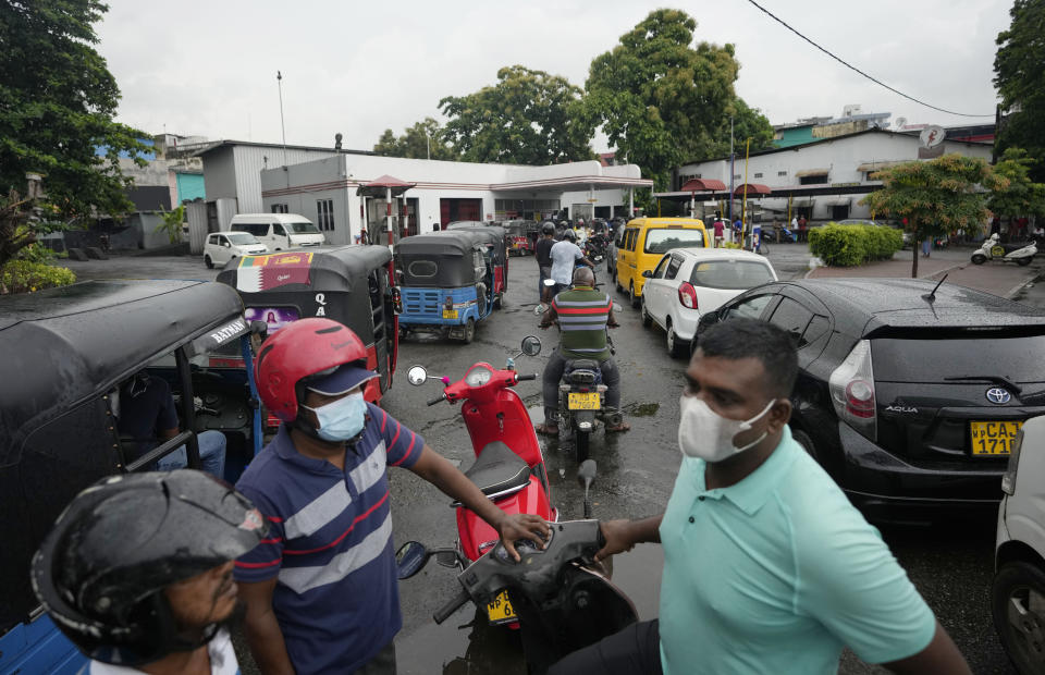 People wait in a long queues to buy fuel for their vehicles at a filling station in Colombo, Sri Lanka, Saturday, June 11, 2022. Sri Lanka's prime minister says he may be compelled to buy more oil from Russia as he hunts desperately for more fuel to keep the country running. In an interview with The Associated Press on Saturday, Prime Minister Ranil Wickremesinghe said if the island nation can get the oil from other sources, it will. (AP Photo/Eranga Jayawardena)