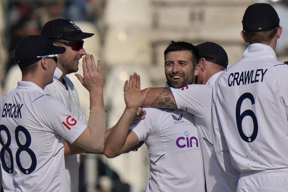 England's Mark Wood, center, celebrates with teammates after taking wicket of Pakistan's Abdullah Shafique during the third day of the second test cricket match between Pakistan and England, in Multan, Pakistan, Sunday, Dec. 11, 2022. (AP Photo/Anjum Naveed)