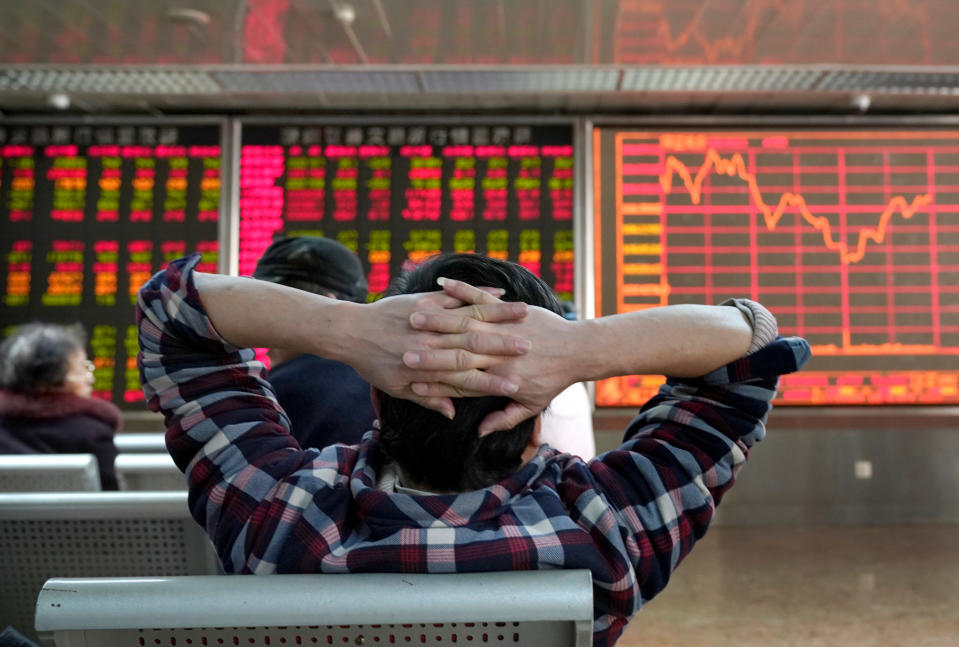 An investor looks at a stock quotation board at a brokerage office in Beijing, China January 3, 2020. REUTERS/Jason Lee