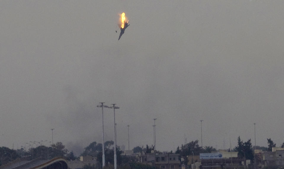 FILE - In this Saturday, March 19, 2011 file photo made by Associated Press photographer Anja Niedringhaus, a warplane of Moammar Gadhafi's forces is shot down over the outskirts of Benghazi, eastern Libya, Saturday, March 19, 2011. Niedringhaus, 48, an internationally acclaimed German photographer, was killed and an AP reporter was wounded on Friday, April 4, 2014 when an Afghan policeman opened fire while they were sitting in their car in eastern Afghanistan. (AP Photo/Anja Niedringhaus, File)