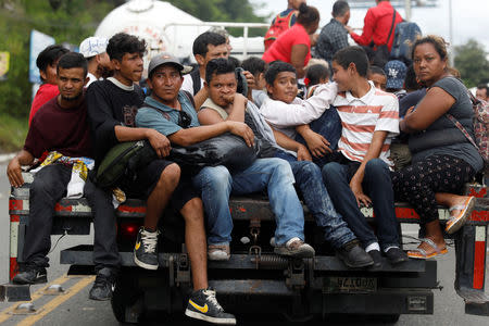 Honduran migrants, part of a caravan trying to reach the U.S., are seen on a truck during a new leg of her travel in Zacapa, Guatemala October 17, 2018. REUTERS/Edgard Garrido