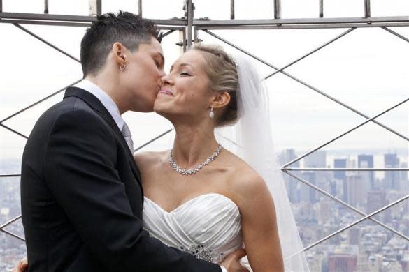 Lela McArthur (R) and Stephanie Figarelle, both from Anchorage, AK, kiss on the observation desk of the Empire State Building after being married on the 61st floor in New York, February 14, 2012. Lucky couples have been married each year on Valentine Day's on the top of the Empire State Building for nearly two decades but this year for the first time two same sex couples said "I do" at the iconic New York landmark. The sky-high nuptials followed the legalization of gay marriage in June when Democratic Gov. Andrew Cuomo signed the law making New York the sixth, and most populous U.S. state, to approve gays and lesbians to wed.