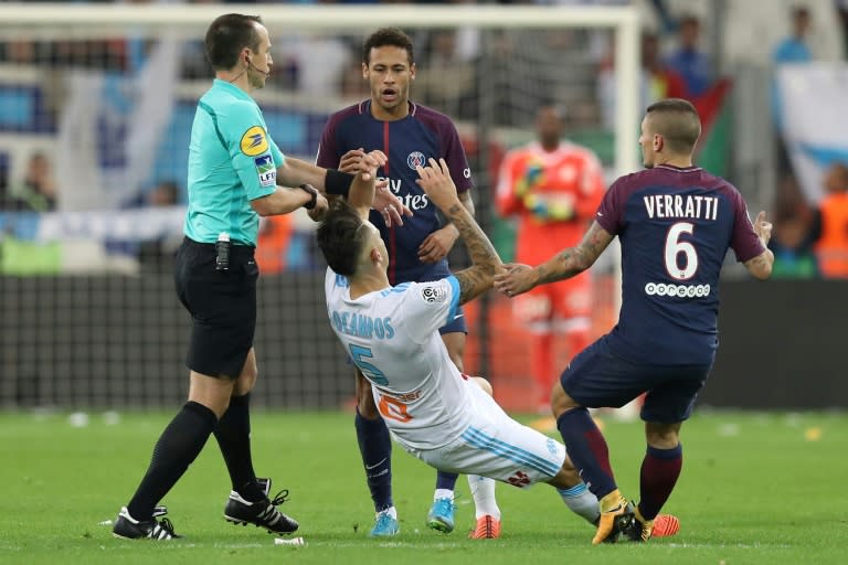 Marseille forward Lucas Ocampos (C) falls after an altercation with Paris Saint-Germain forward Neymar (C, top) during the French L1 at the Velodrome Stadium in Marseille, France on October 22, 2017