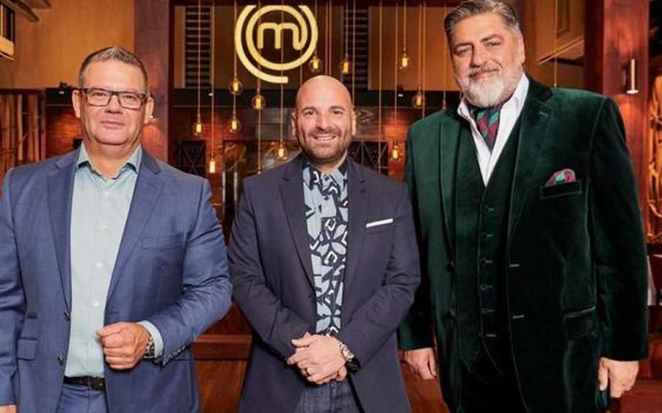 Standing on the set in suits, the original judges from Masterchef Australia Gary Mehigan, George Calombaris and Matt Preston.