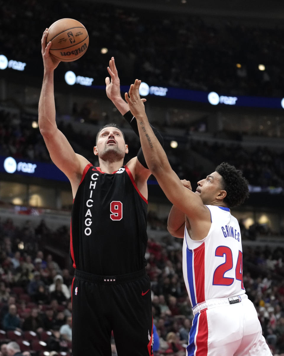 Chicago Bulls' Nikola Vucevic (9) shoots as Detroit Pistons' Quentin Grimes defends during the first half of an NBA basketball game Tuesday, Feb. 27, 2024, in Chicago. (AP Photo/Charles Rex Arbogast)