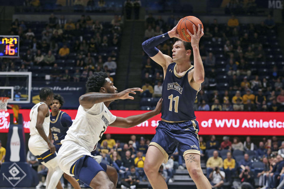 Mount St. Mary's forward George Tinsley (11) looks for an outlet as West Virginia guard Kobe Johnson (2) defends during the first half of an NCAA college basketball game in Morgantown, W.Va., Monday, Nov. 7, 2022. (AP Photo/Kathleen Batten)