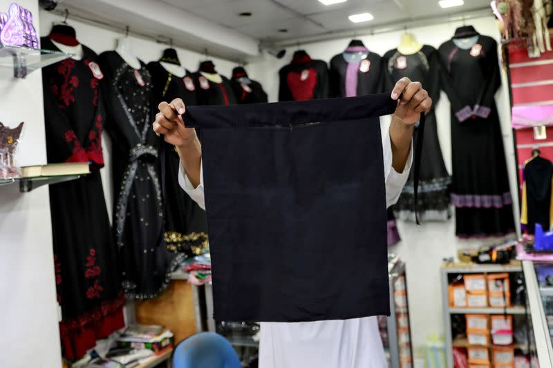 FILE PHOTO: A salesman shows a full face veil niqab at a shop selling various kinds of coverings worn by Muslim women in Colombo