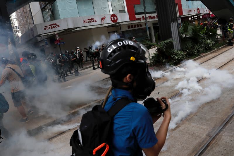 Riot police fire tear gas to disperse anti-government protesters during a march against Beijing's plans to impose national security legislation in Hong Kong