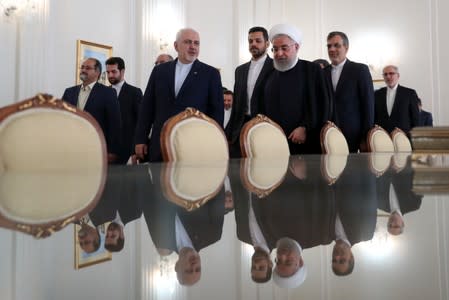 Iranian President Hassan Rouhani walks with Iran's Foreign Minister Mohammad Javad Zarif during a meeting in Tehran