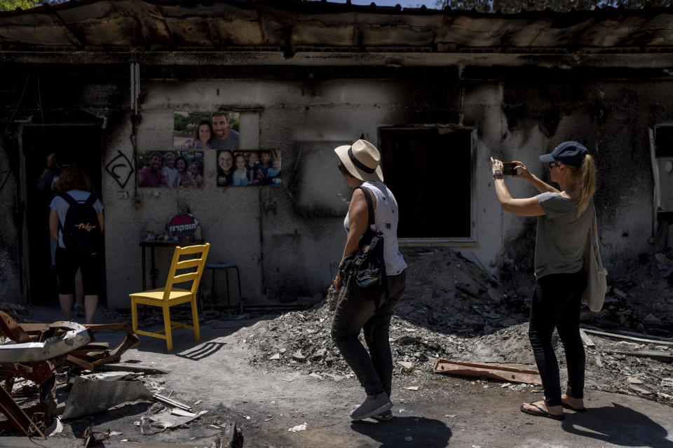 A group of Israelis on an educational tour visit the home of the Siman Tov family on Friday, June 21, 2024. The parents and three children were killed and their home was torched by Hamas militants on the Oct. 7 attack on Israel, in Kibbutz Nir Oz in southern Israel. A new kind of tourism has emerged in Israel in the months since Hamas’ Oct. 7 attack. For celebrities, politicians, influencers and others, no trip is complete without a somber visit to the devastated south that absorbed the brunt of the assault near the border with Gaza. (AP Photo/Ohad Zwigenberg)