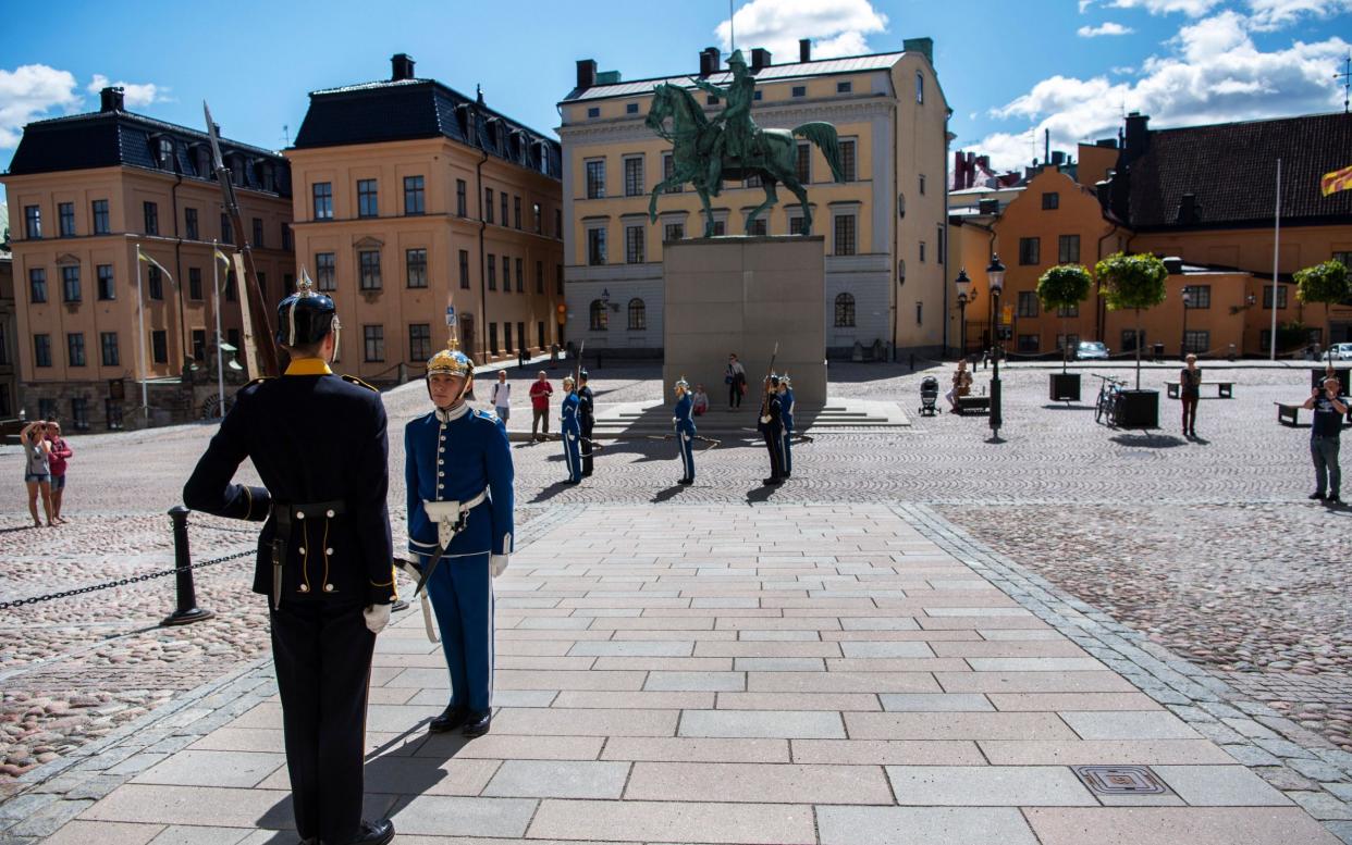 Two soldiers in traditional uniform perform the changing of guards outside the Royal Palace in Stockholm, Sweden, 22 July 2020 - Ali Lorestani/TT/EPA-EFE/Shutterstock