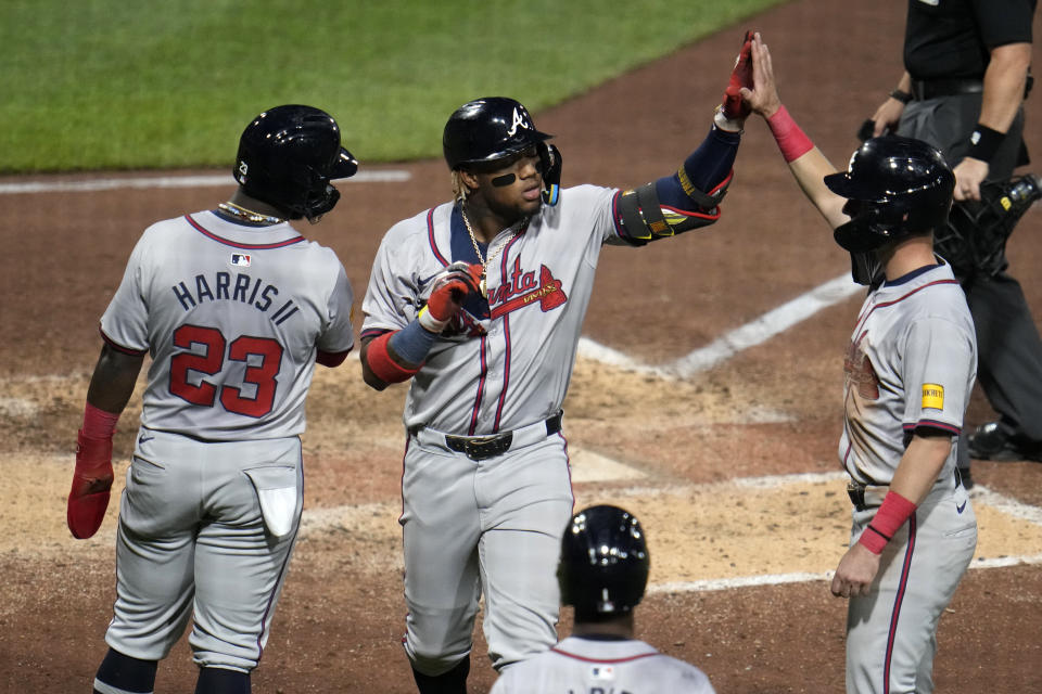 Atlanta Braves' Ronald Acuña Jr., center, is greeted by Michael Harris II (23) and Zack Short, right, after hitting a three-run home run off Pittsburgh Pirates starting pitcher Bailey Falter during the eighth inning of a baseball game in Pittsburgh, Friday, May 24, 2024. (AP Photo/Gene J. Puskar)