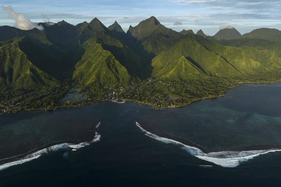 The surf breaks onto the lagoon in Teahupo'o, Tahiti, French Polynesia, Saturday, Jan. 13, 2024. The decision to host part of the Olympic Games here has thrust unprecedented challenges onto a small community that has long cherished and strives to protect its way of life. (AP Photo/Daniel Cole)