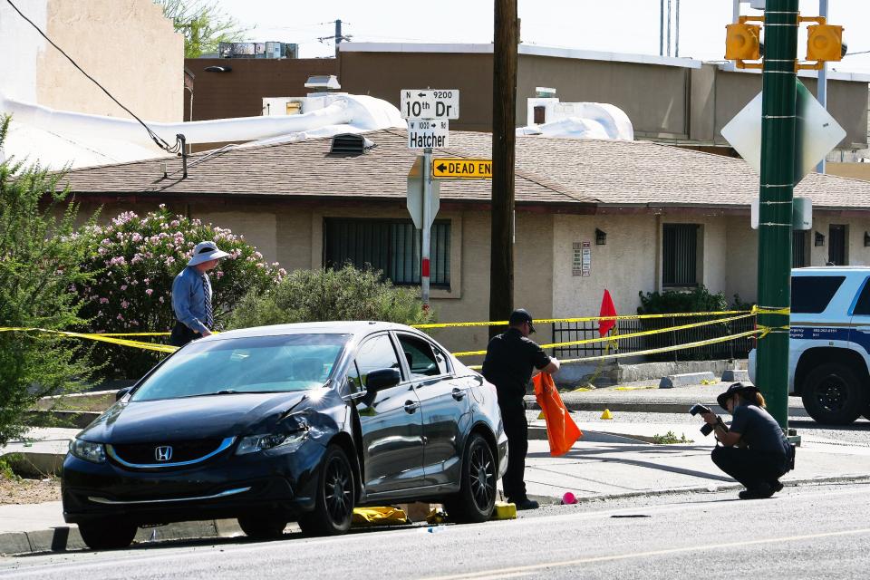 Officers collect evidence near the corner of West Hatcher Road and North Tenth Avenue on Saturday, June 4, 2022, in Phoenix. Investigators collected evidence around the scene of a mass shooting that left one 14-year-old girl dead and eight others injured.