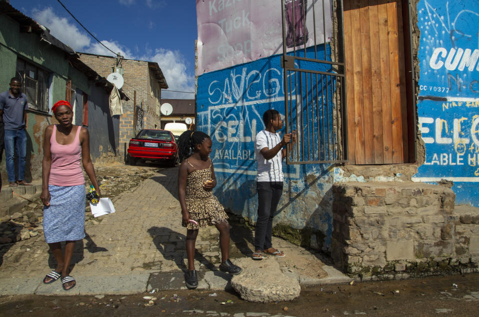 Residents watch as South African National Defence Forces, patrol on the street of a densely populated Alexandra township in Johannesburg, South Africa, Thursday, April 16, 2020. South African President Cyril Ramaphosa extended the lockdown by an extra two weeks in a continuing effort to contain the spread of COVID-19 coronavirus. (AP Photo/Themba Hadebe)