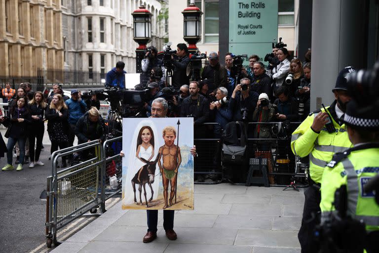 La artista de sátira política Kaya Mar sostiene una pintura que retrata al Príncipe Harry de Gran Bretaña, Duque de Sussex, y a su esposa Meghan de Gran Bretaña, Duquesa de Sussex, afuera del tribunal donde transcurre el caso