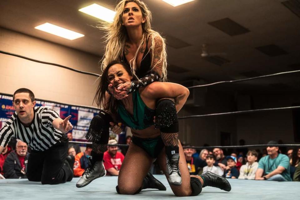 At IWR-27 Vengeance, Shelley The Bombshell Benson puts Ashley D'Amboise in a camel clutch.