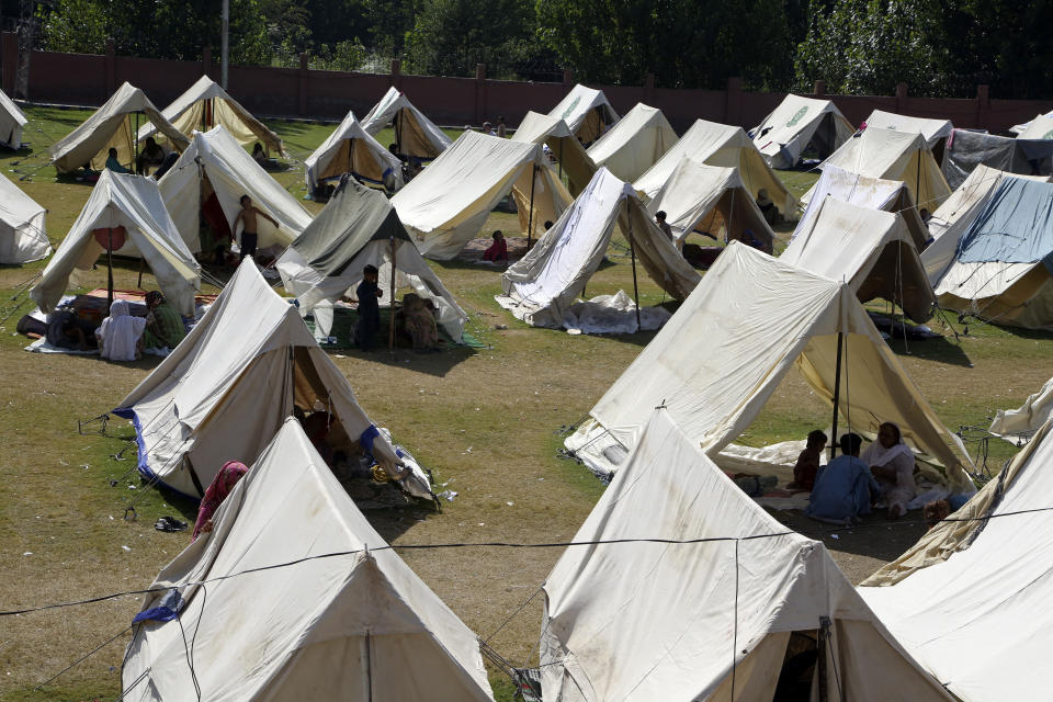 Displaced families take refuge at a tent camp after fleeing their flood-hit homes, in Charsadda, Pakistan, Tuesday, Aug. 30, 2022. Disaster officials say nearly a half million people in Pakistan are crowded into camps after losing their homes in widespread flooding caused by unprecedented monsoon rains in recent weeks. (AP Photo/Mohammad Sajjad)