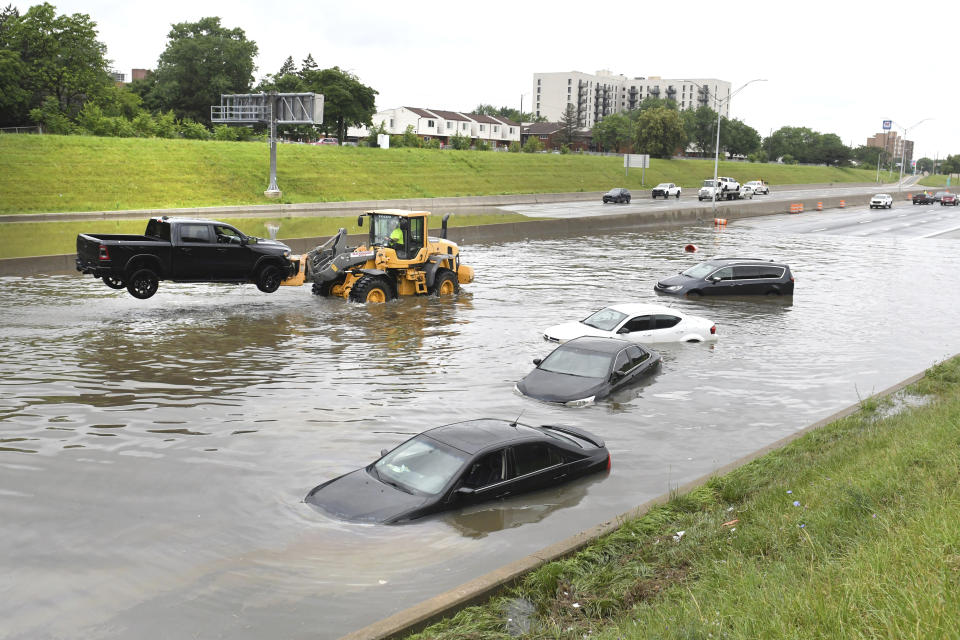 A truck is hoisted from a flooded I75 and Canfield Street as heavy rain flooded streets in the metro area of Detroit, on Saturday, June 26, 2021. A state of emergency has been declared for Detroit and surrounding Wayne County following daylong rain that flooded freeways and streets. (Max Ortiz/Detroit News via AP)