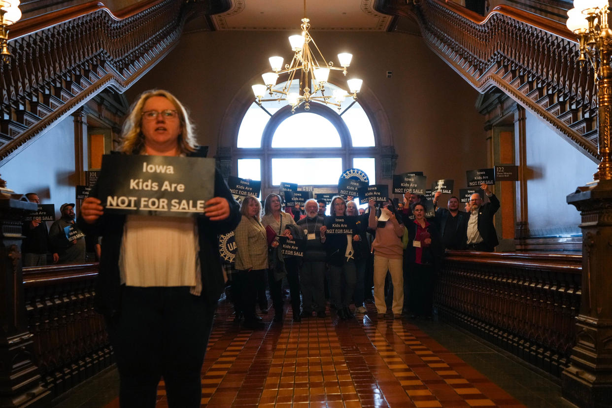 Protestors stand with signs during a rally against bills that would loosen Iowa's child labor laws at the Iowa State Capitol in Des Moines, IA on Monday, Feb. 27, 2023.