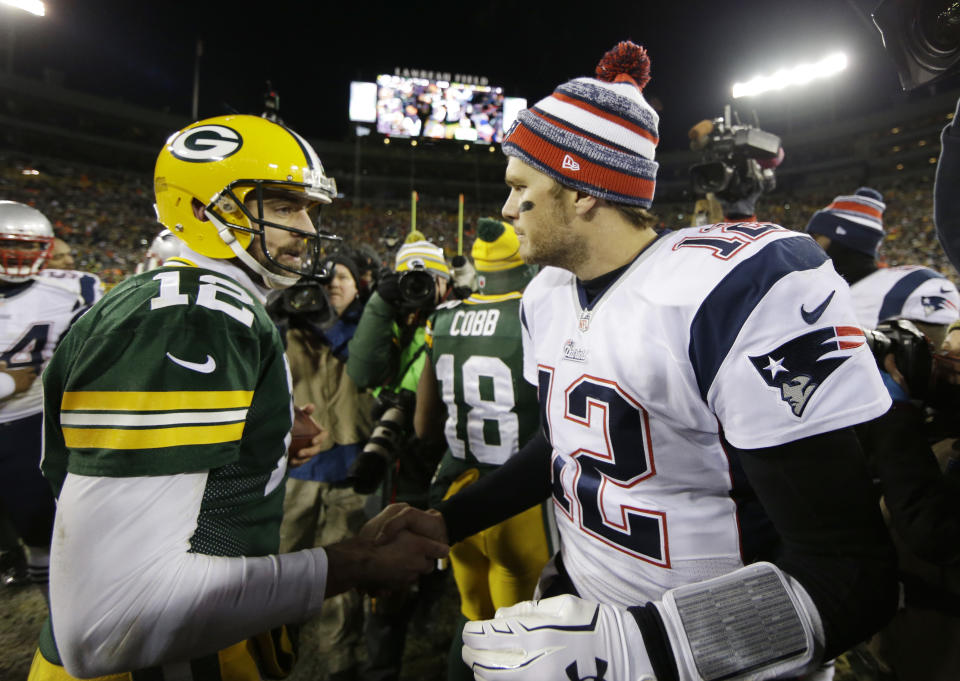 Tom Brady and Aaron Rodgers meet on the field after a 2014 game. (AP)
