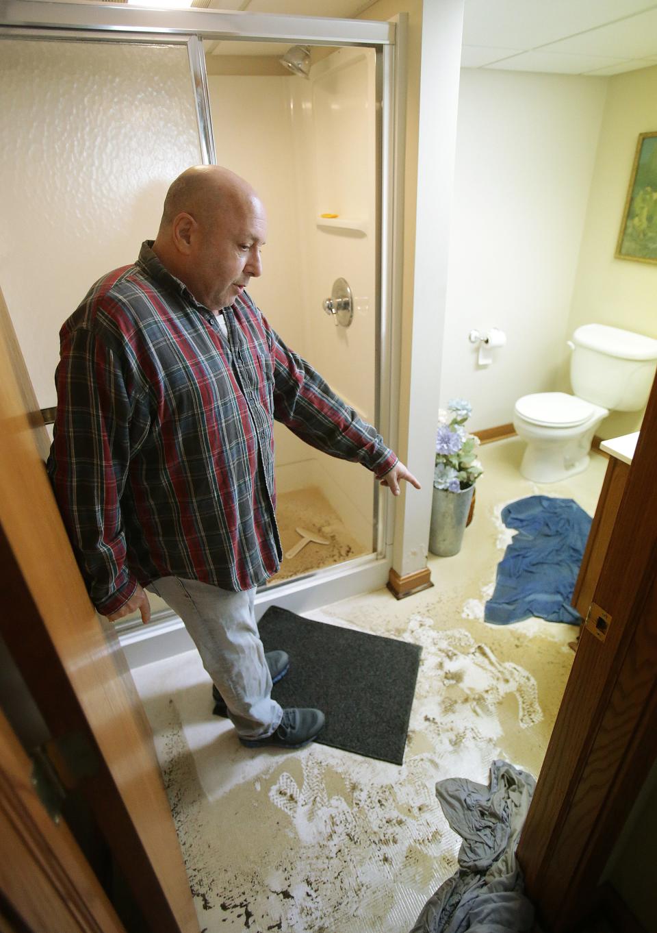 North Canton resident Dan Schoenberg  stands in his basement that was recently flooded with raw sewage. 