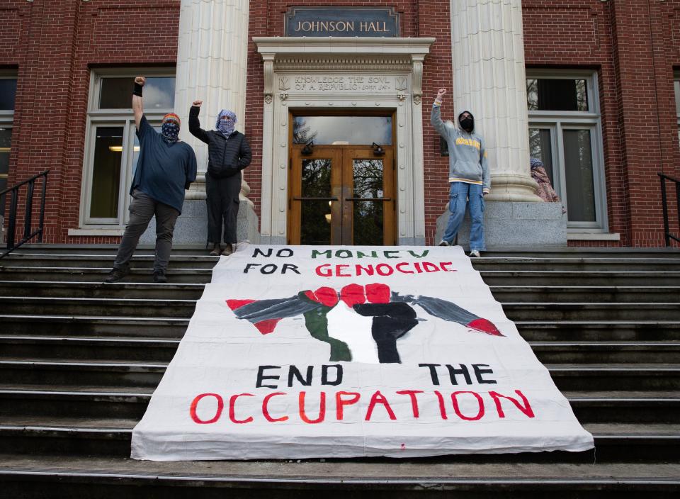 Pro-Palestinian protesters lay a banner on the steps of Johnson Hall at the University of Oregon campus in support of a cease fire in Gaza.