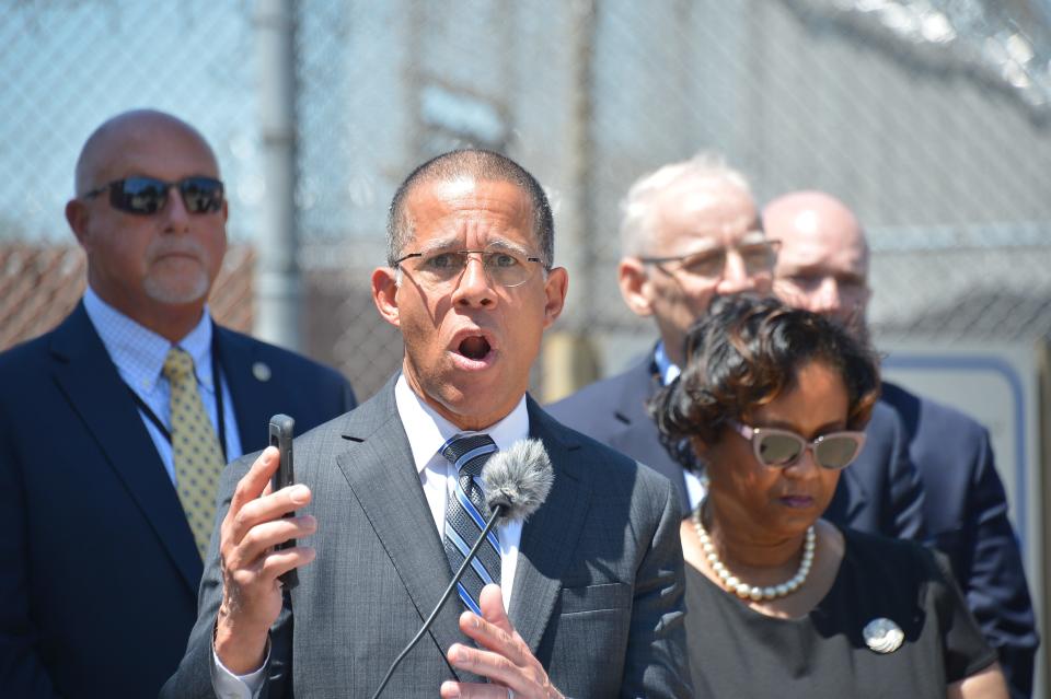 Attorney General Anthony G. Brown holds his phone in the air at a Roxbury Correctional Institution press conference Thursday as he speaks about the dangers of contraband cellphones being smuggled into prisons.