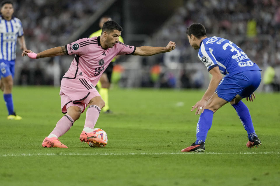 Inter Miami's Luis Suarez, left, dribbles the ball in front of Monterrey's Stefan Medina during a CONCACAF Champions Cup quarter final second leg soccer match at the BBVA stadium in Monterrey, Mexico, Wednesday, April 10, 2024. (AP Photo/Eduardo Verdugo)