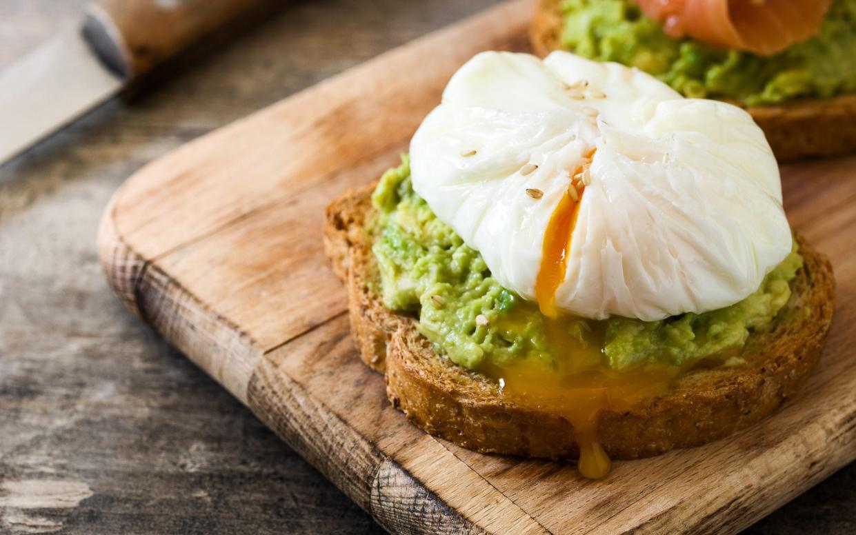 Avocado toast with poached eggs makes a good hangover meal - Alamy 