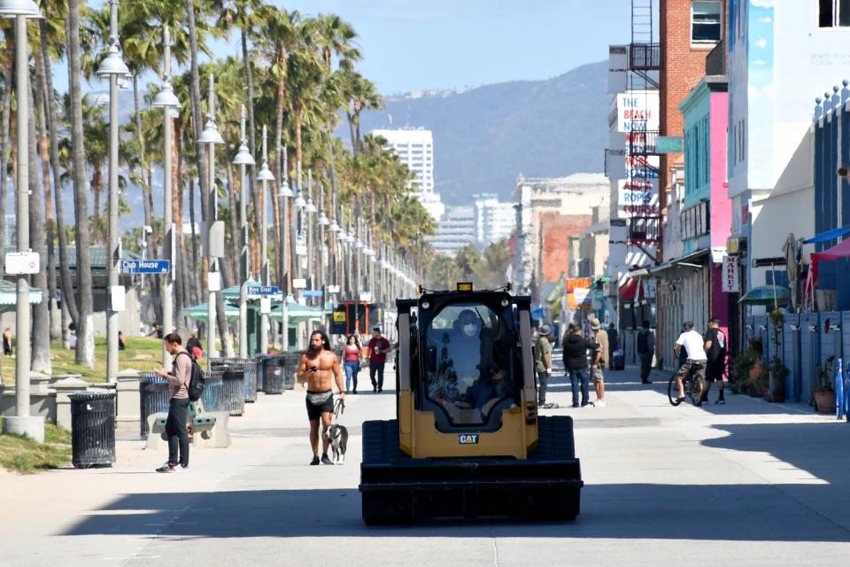 On the first day that L.A. County beaches reopened after closing because of coronavirus, a steady stream of government vehicles helped keep people moving on Venice Beach's Ocean Front Walk.