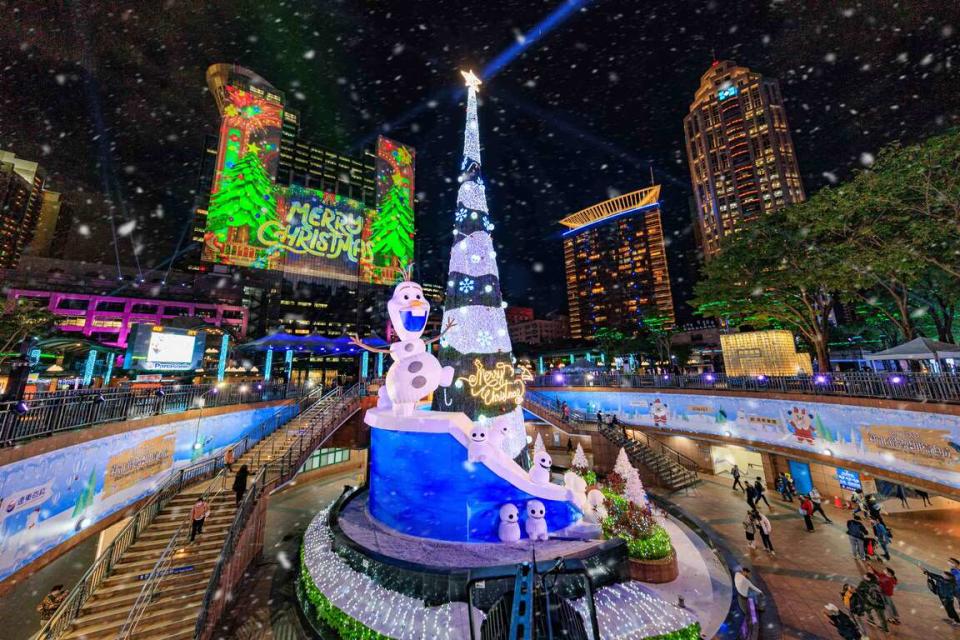 2022年新北歡樂耶誕城於11日開幕。冰雪奇緣的雪寶，登上由竹筍地標化身的雪白耶誕樹，後方市府大樓上可見光雕投影。   圖：新北市觀光旅遊局提供
