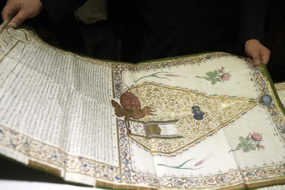 Father Theophilos, a Pantokrator monk, holds a manuscript at the library of Pantokrator Monastery in the Mount Athos, northern Greece, on Thursday, Oct. 13, 2022. Deep inside a medieval fortified monastery in the Mount Athos monastic community, researchers are for the first time tapping a virtually unknown treasure: thousands of Ottoman-era manuscripts that include the oldest of their kind in the world. (AP Photo/Thanassis Stavrakis)