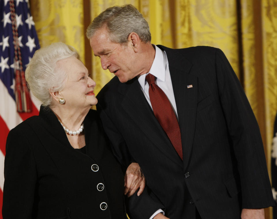 FILE - In this file photo dated Monday, Nov. 17, 2008, US President George W. Bush greets actress Olivia de Havilland as he presented her with the 2008 National Medals of Arts, in the East Room of the White House in Washington, USA. Olivia de Havilland, Oscar-winning actress has died, aged 104 in Paris, publicist says Sunday July 26, 2020. (AP Photo/Gerald Herbert, FILE)