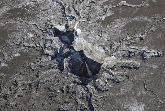 Wasser läuft in ein riesiges Erdloch auf dem Mosaic Co. Grundstück in Mulberry, Florida. Menschen, die in der Umgebung, des Erdlochs leben, welches Massen an kontaminiertem Wasser und Düngerabfällen ins Grundwasser leitet, sind empört darüber, dass sie nicht schon eher über das Desaster informiert wurden. Viele warten noch immer auf die Ergebnisse der Untersuchungen, die Aufschluss darüber geben sollen, ob giftige Chemikalien und Strahlung in ihr Trinkwasser gelangt sind. (Bild: AP Photo/Chris)