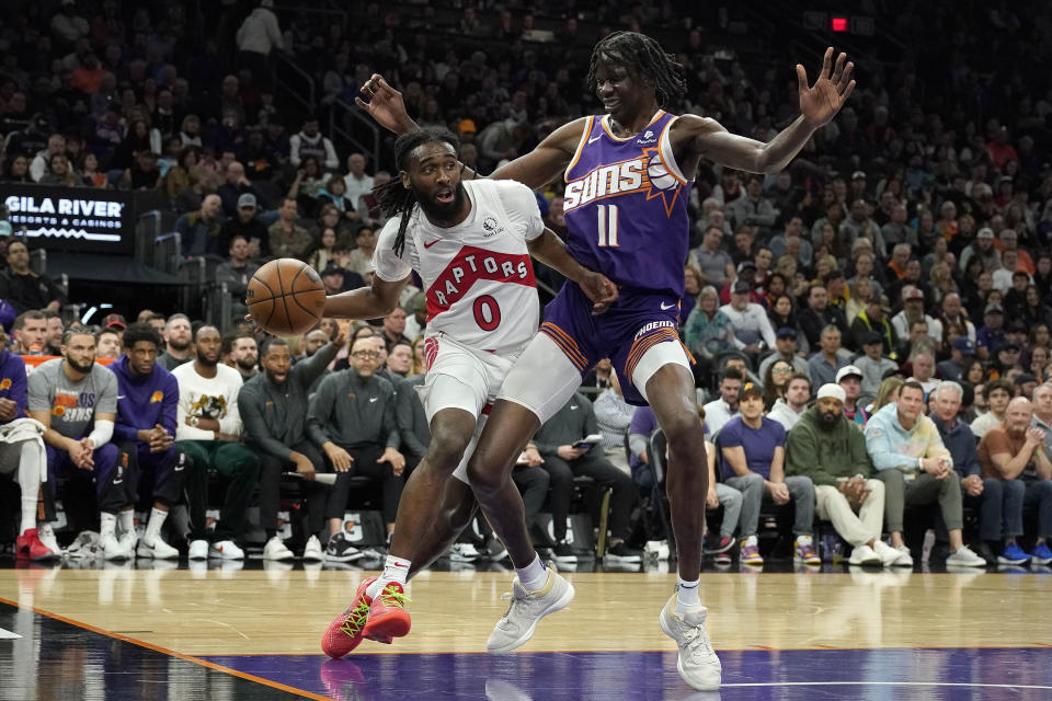 Toronto Raptors guard Javon Freeman-Liberty (0) works to get around Phoenix Suns center Bol Bol (11) in during the first half of an NBA basketball game in Phoenix, Thursday, March. 7, 2024. (AP Photo/Darryl Webb)