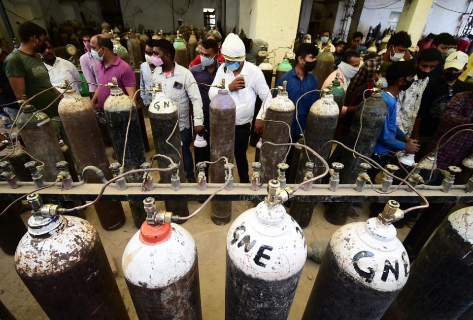 People refill medical oxygen cylinders for Covid patients at an oxygen refill station in Allahabad, 20 April