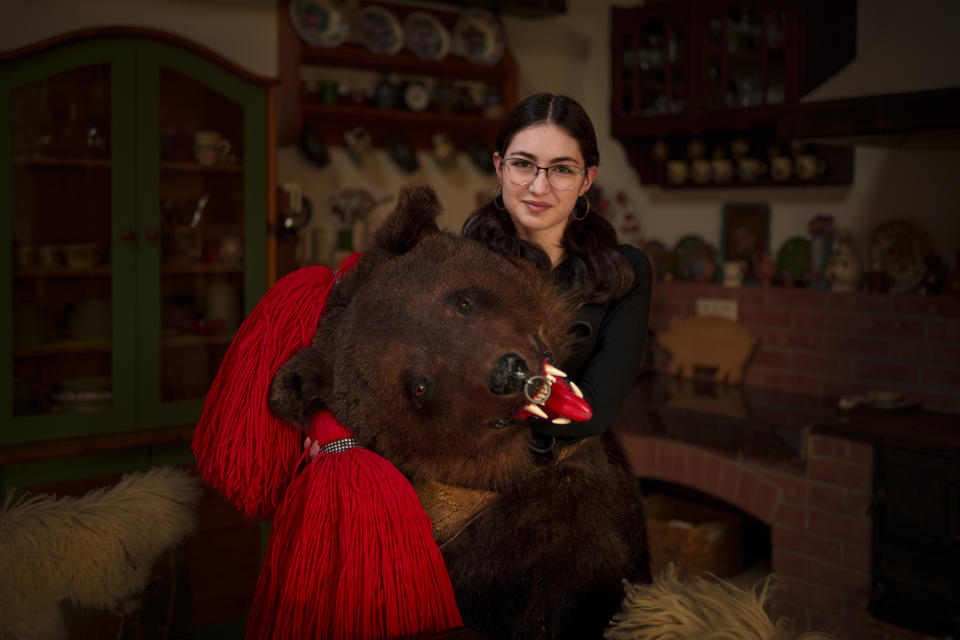 Denisa, 15 years-old, a member of the Sipoteni bear pack, poses for a portrait in Comanesti, northern Romania, Wednesday, Dec. 27, 2023. Denisa first wore the bear fur costume when she was 10 years-old loves to dance along with her fellow pack members. (AP Photo/Andreea Alexandru)
