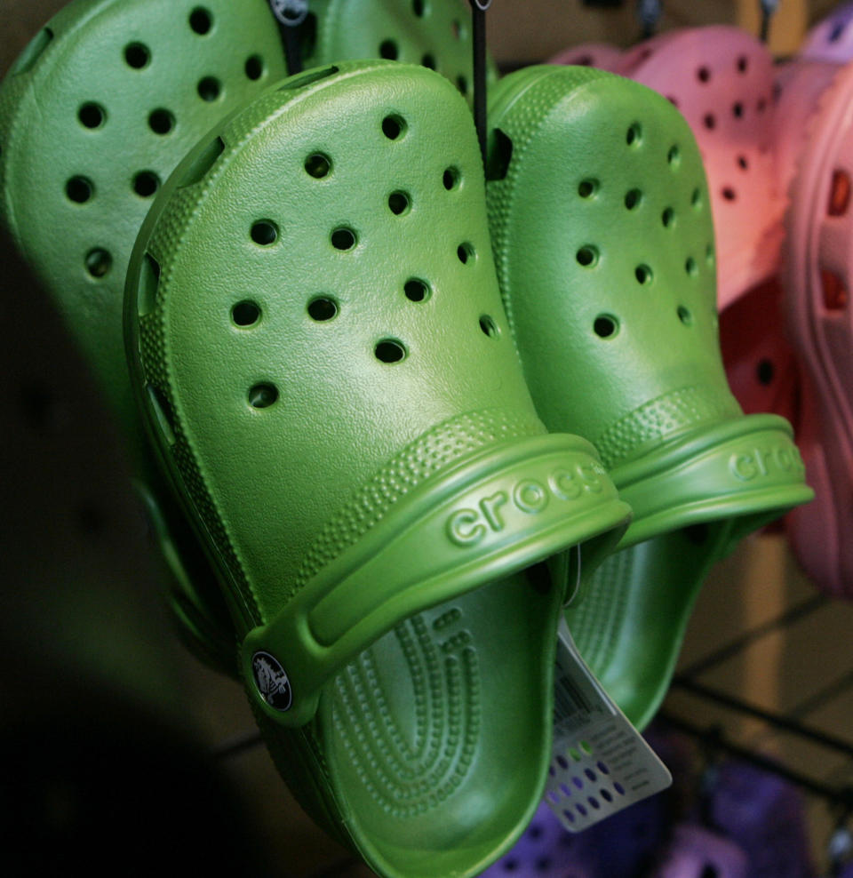 FILE- In this Feb. 6, 2006, file photo, Crocs colorful resin footwear are on display at the REI flagship store in Denver. Colorado-based casual footwear company Crocs Inc., is closing company-owned manufacturing plants in Italy and Mexico by the end of the year and replacing its chief financial officer. The company announced the outsourcing of additional manufacturing and the closure of a distribution facility in Mexico Tuesday, Aug. 7, 2018, while reporting a second-quarter profit of $30.4 million, or 35 cents per share. (AP Photo/Ed Andrieski, File)