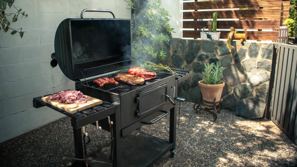 A grill cooking in a backyard