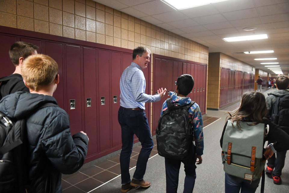 Darren Ellwein, principal at South Middle School, chats with students in the hallway between classes on Friday, March 3, 2023, in Harrisburg.